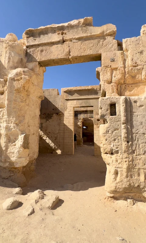 بوابة حجرية ضخمة لمعبد الوحي في أغورمي تنفتح على أبواب داخلية.